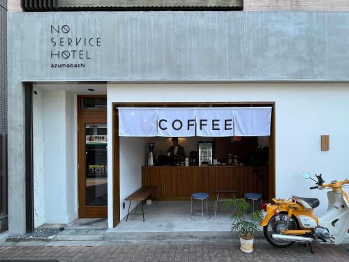 a coffee shop with a motorcycle parked outside of it at NO SERVICE HOTEL azumabashi in Tokyo