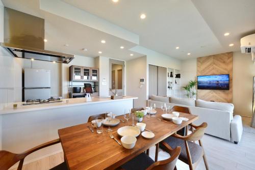a dining room and kitchen with a wooden table and chairs at Branchera Naha Akebono Premist R65 in Nakanishi