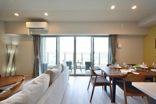 a living room with a large couch and a table at Branchera Naha Akebono Premist R65 in Nakanishi