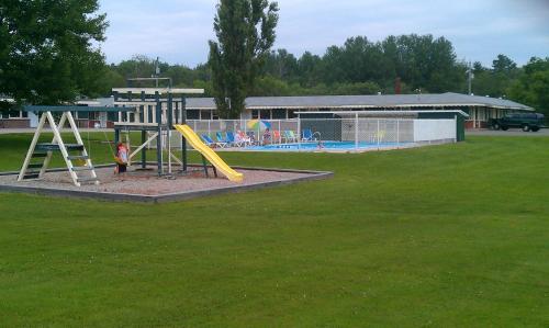 a playground with a yellow slide in a park at Middleton Motel & Suites in Middleton