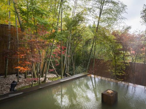 a pool of water in a yard with trees at Hikyou Shirakawagensen Sansou Takefue in Minamioguni