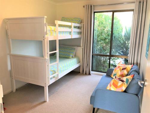 a room with a bunk bed and a blue couch at Kangaview in Venus Bay