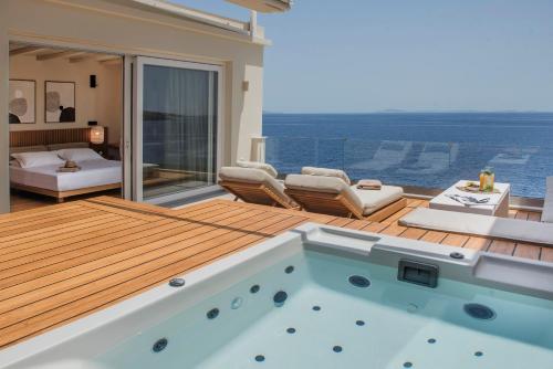 a room with a swimming pool and a bedroom at Anaya Suites in Ermoupoli