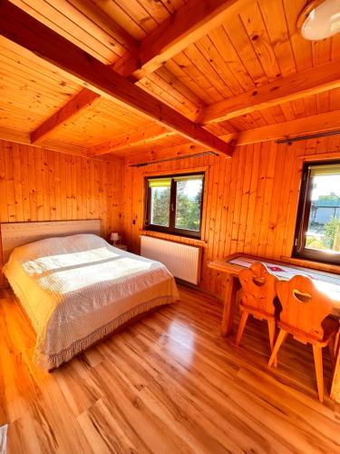 une chambre avec un lit, un bureau et des fenêtres dans l'établissement Z widokiem na Giewont, à Kościelisko