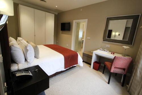 a hotel room with a bed and a desk at Cae Court Hotel in Bridgend