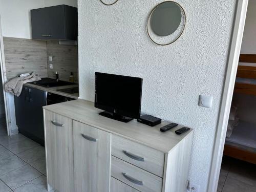 - une cuisine avec un comptoir et une télévision dans l'établissement Appartement paisible 3 personnes, à Leucate