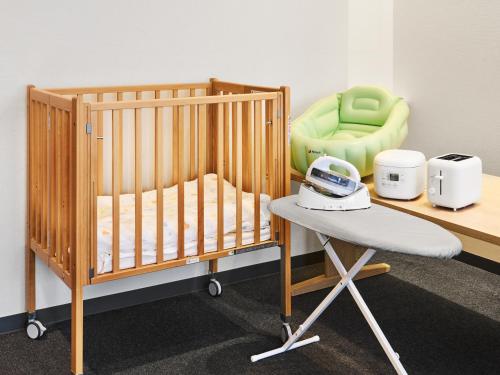 a crib and a chair in a room at MIMARU Osaka Namba North in Osaka