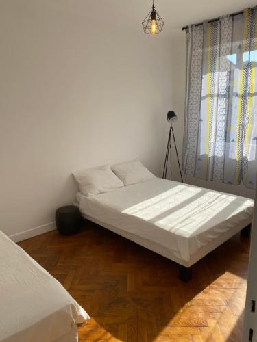a bedroom with a white bed and a window at Appartement Flores in Nice