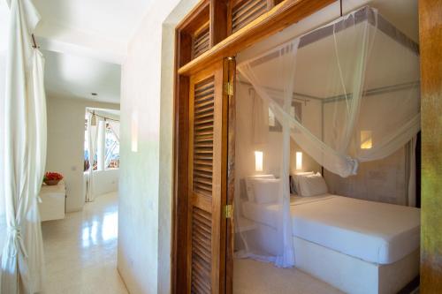 a bedroom with a bed with a canopy at Palm Garden ECO Boutique Hotel No Kids under 12 in Watamu
