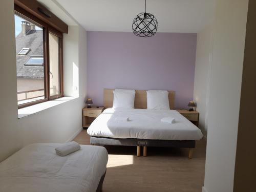 a bedroom with two beds and a window at Gîte du Haut Morvan in Arleuf