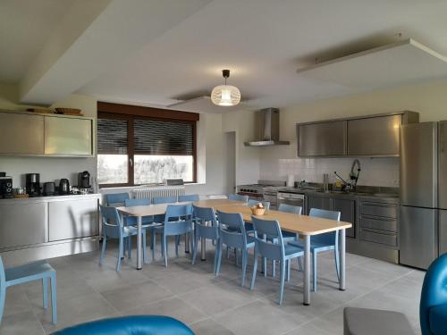 a kitchen with tables and chairs in a kitchen at Gîte du Haut Morvan in Arleuf