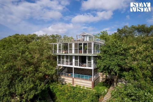 an aerial view of a house in the trees at The Glasscape by StayVista - Hillside getaway with Pool and Indoor games in Nashik