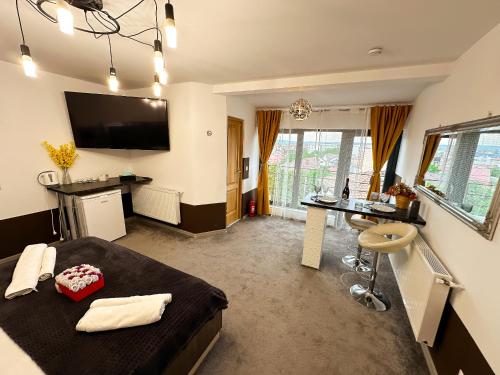 a bedroom with a bed and a desk and a television at Elixir Central Studio with Balcony & Panoramic View in Craiova