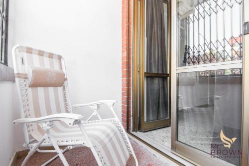 a white rocking chair sitting on a balcony at MrBrown - Pincherle Room in Rome