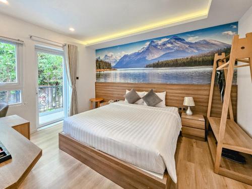 a bedroom with a large bed and a painting of mountains at NATURE LAND 2 - Song Anh Hotel Dalat in Da Lat