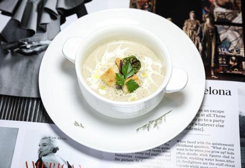 a cup of soup on a plate on a magazine at Huangshan Taiping Lake Muxin Hotel in Fenghuangshan