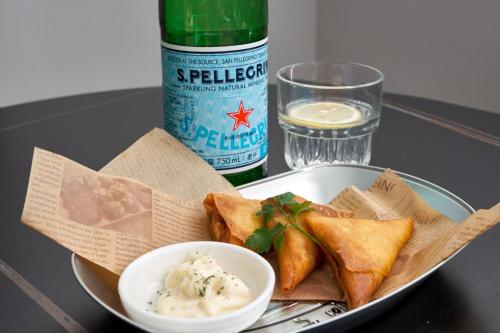 a plate of food with a bowl of dips and a bottle at Huangshan Taiping Lake Muxin Hotel in Fenghuangshan