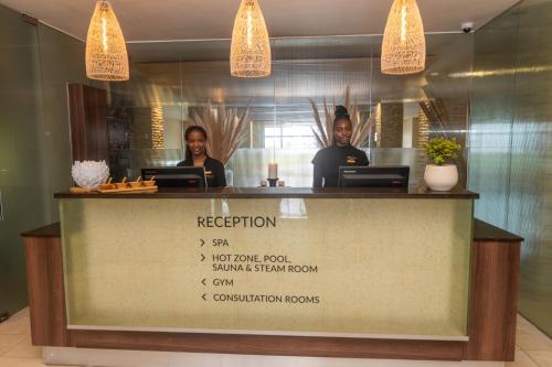 two people standing behind a counter in a restaurant at Pezula Nature Retreat in Knysna