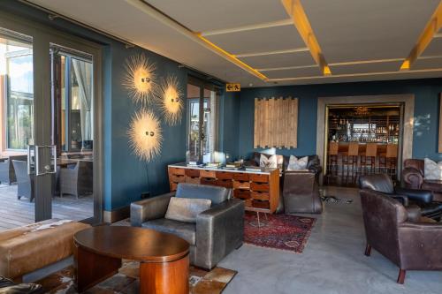 a living room with blue walls and leather furniture at Pezula Nature Retreat in Knysna