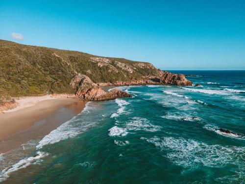 an aerial view of a beach with rocks in the ocean at Pezula Nature Retreat in Knysna