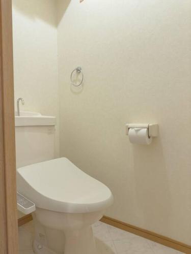a white bathroom with a toilet and a sink at urban stay 西新 in Muromimachi