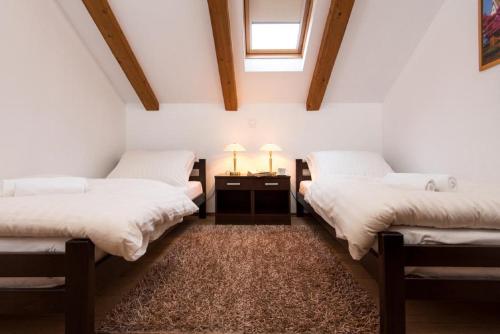 two beds in a room with white walls at Apartments Zavala in Ravno