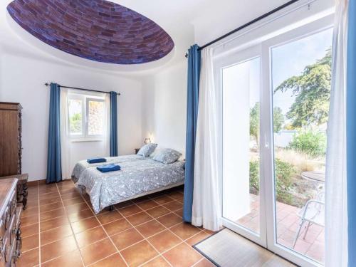 a bedroom with a bed and a large sliding glass door at Casa Cinco Cupulas in Armação de Pêra