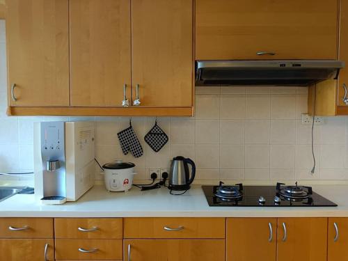 a kitchen with wooden cabinets and a stove top oven at Fahrenheit 88 Suites Bukit Bintang by Roseline 2R in Kuala Lumpur