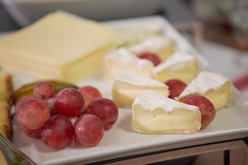 a plate of cheeses and grapes on a table at Kapellerhof in Stadl-Paura