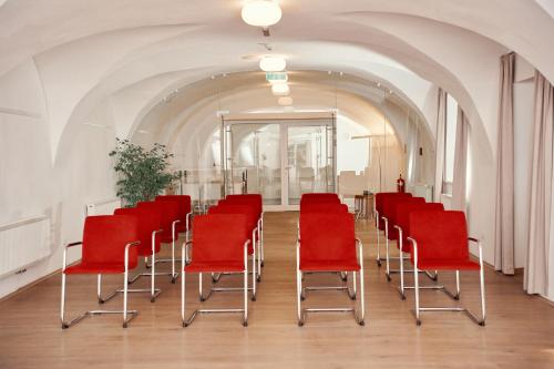 a row of red chairs in a room at Kapellerhof in Stadl-Paura