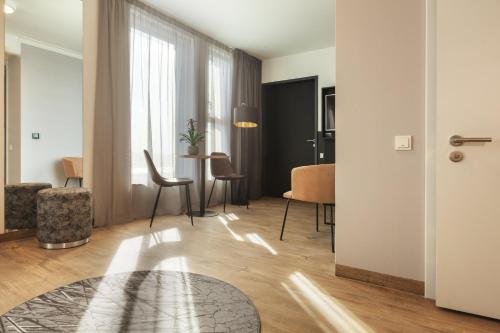 a living room with a table and chairs at Holiday Inn - the niu, Leo Nuremberg by IHG in Nürnberg