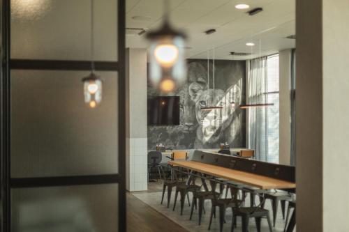 a dining room with a long table and chairs at Holiday Inn - the niu, Leo Nuremberg by IHG in Nürnberg