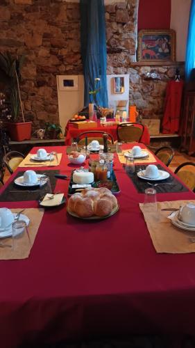 a table with a red table cloth with food on it at Les deux arches in Caunes-Minervois