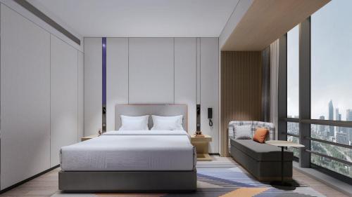 a bedroom with a bed and a chair at Holiday Inn Express Suzhou East Taihu by IHG in Suzhou