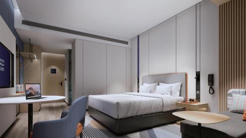 a hotel room with a bed and a chair at Holiday Inn Express Suzhou East Taihu by IHG in Suzhou