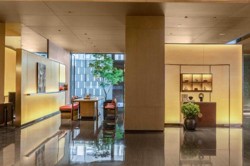 a lobby with a table and chairs in a building at Holiday Inn Express Hangzhou Jiangnan by IHG in Hangzhou