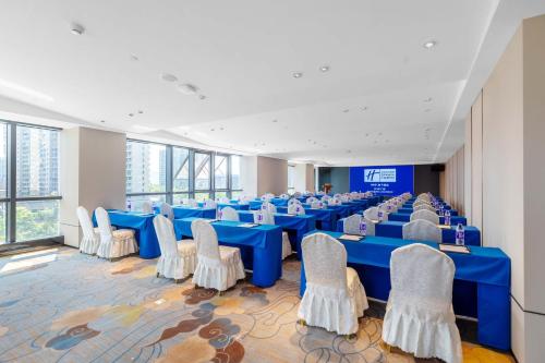 a large room with blue tables and white chairs at Holiday Inn Express Hangzhou Jiangnan by IHG in Hangzhou
