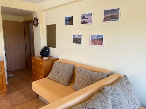 a living room with a couch and pictures on the wall at Laguna Sunset Appatments, sea and mountain view in Primorsko