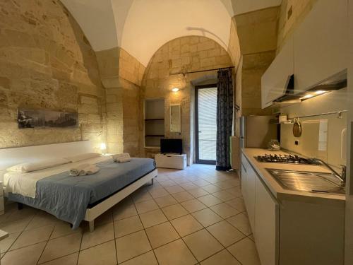 een slaapkamer met een bed en een keuken in een kamer bij Casa Fortunato Corte Adorni in Lecce