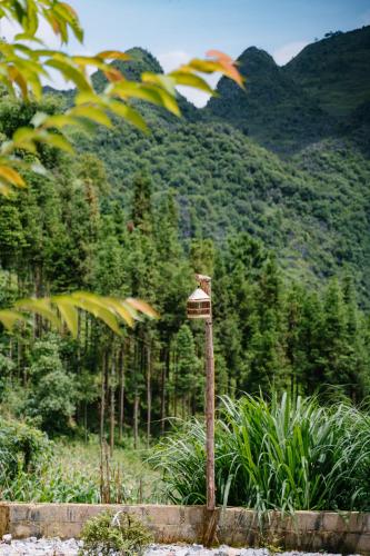 a bird feeder on a pole in front of a mountain at Đồng Văn Golden Hotel in Dồng Văn