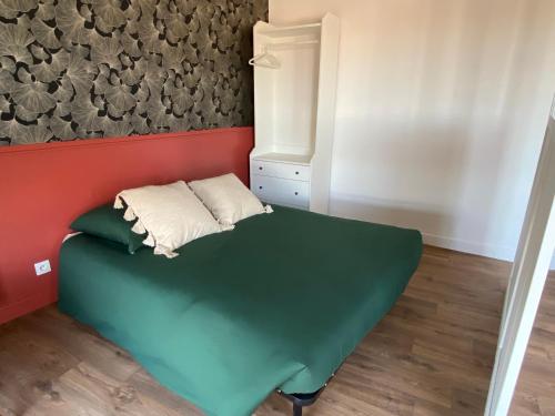 Cette petite chambre d'angle comprend un lit vert. dans l'établissement Appartement Pont Montaudran, à Toulouse
