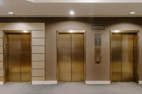 two elevators in a building with a sign on the wall at Club Quarters Hotel Central Loop, Chicago in Chicago