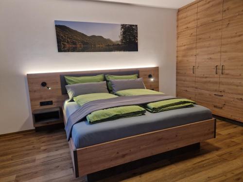 a bedroom with a large bed with a wooden headboard at Haus Schmied in Weissensee