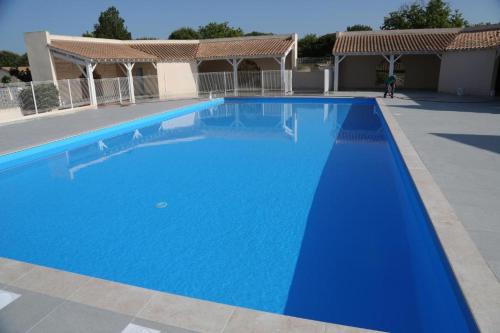 une grande piscine bleue devant un immeuble dans l'établissement Nr 24 Vakantiehuisje Portiragnes Les Marines, à Portiragnes