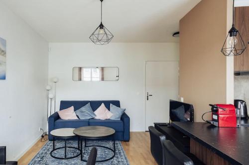 un salon avec un canapé bleu et une table dans l'établissement Évasion Toscane Val d'Europe - Proche Disneyland, à Serris