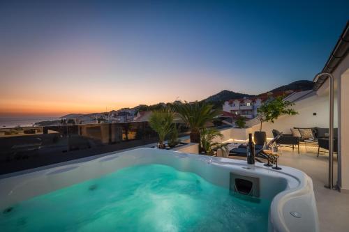 a hot tub on a balcony with a view of the ocean at Luxury Penthouse Hvar with Jacuzzi & Sea View in Hvar