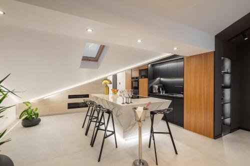 a kitchen with a white table and stools at Luxury Penthouse Hvar with Jacuzzi & Sea View in Hvar