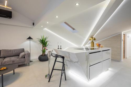 a kitchen with a white island in a living room at Luxury Penthouse Hvar with Jacuzzi & Sea View in Hvar