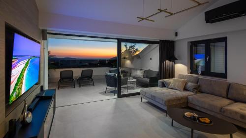 a living room with a couch and a flat screen tv at Luxury Penthouse Hvar with Jacuzzi & Sea View in Hvar