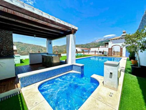 a swimming pool with a patio and a house at Elegant Villa with Jacuzzi in Canillas de Albaida in Canillas de Albaida